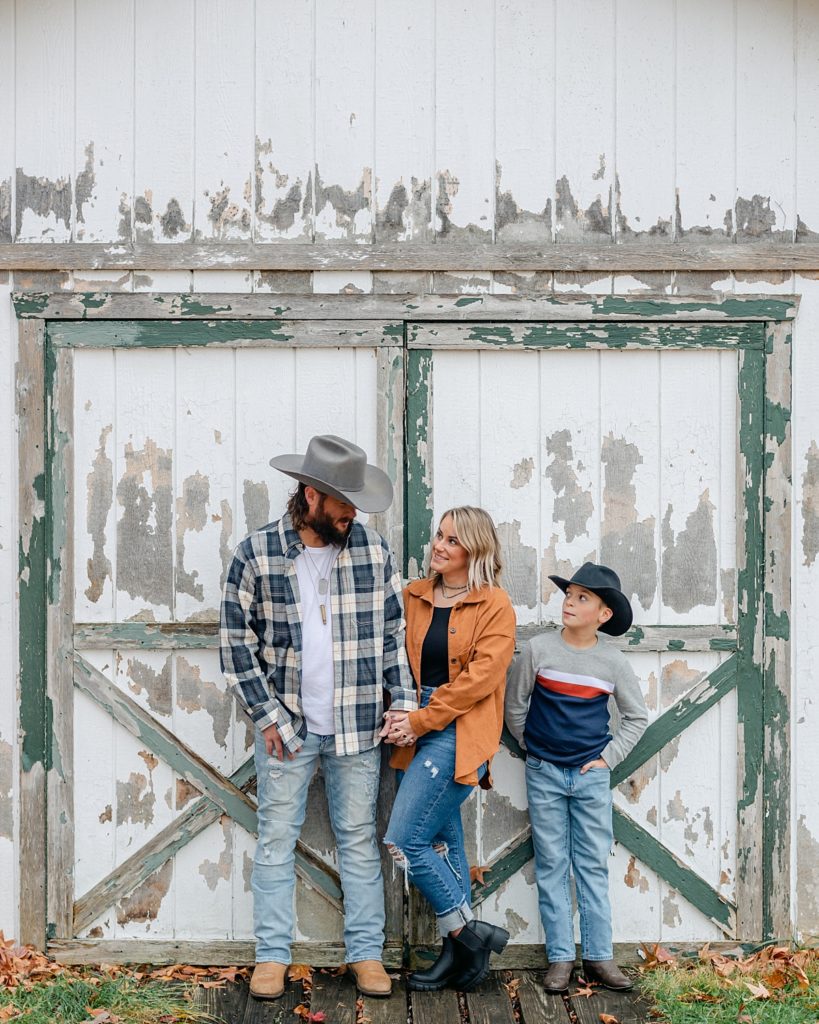 Country family in front of rustic barn